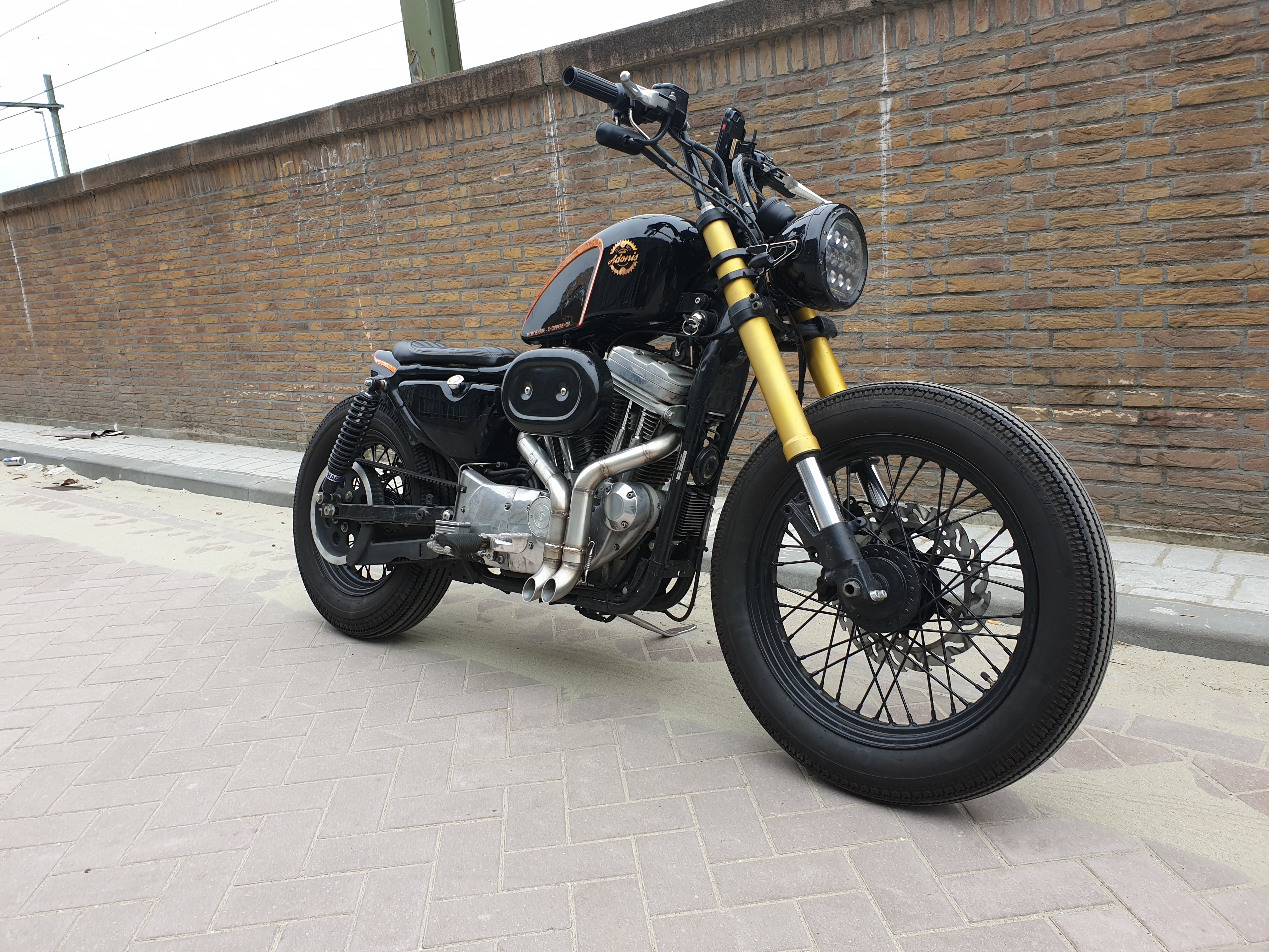 Black Harley-Davidson Sportster bobber with the MAD Exhausts Shorty system, right-side view on the street