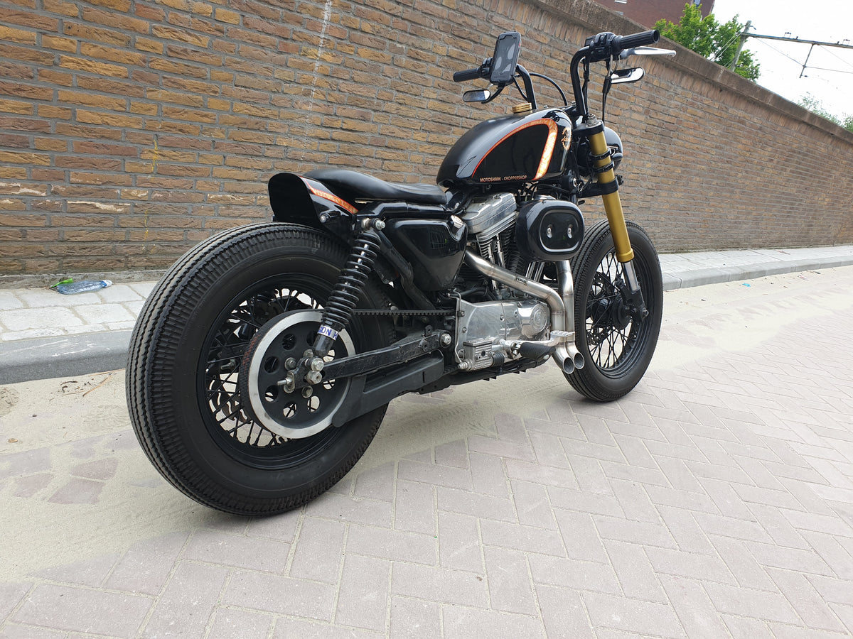 Rear three-quarter view of the black Harley-Davidson Sportster bobber showing the twin MAD Exhausts Shorty outlets