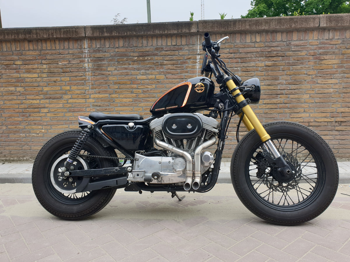 Black Harley-Davidson Sportster bobber with the MAD Exhausts Shorty twin-outlet system, full left-side view