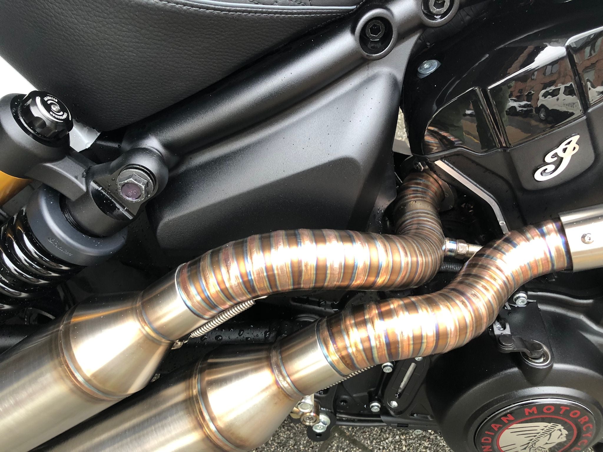 Close-up of the twin down-swept MAD Exhausts silencers with heat-blued stainless steel, mounted on the Indian Scout 1250