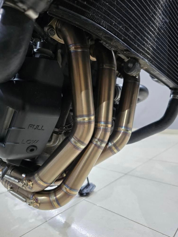 Three MAD Exhausts stainless steel header pipes with heat-blued finish running from the Yamaha CP3 engine, front-low view