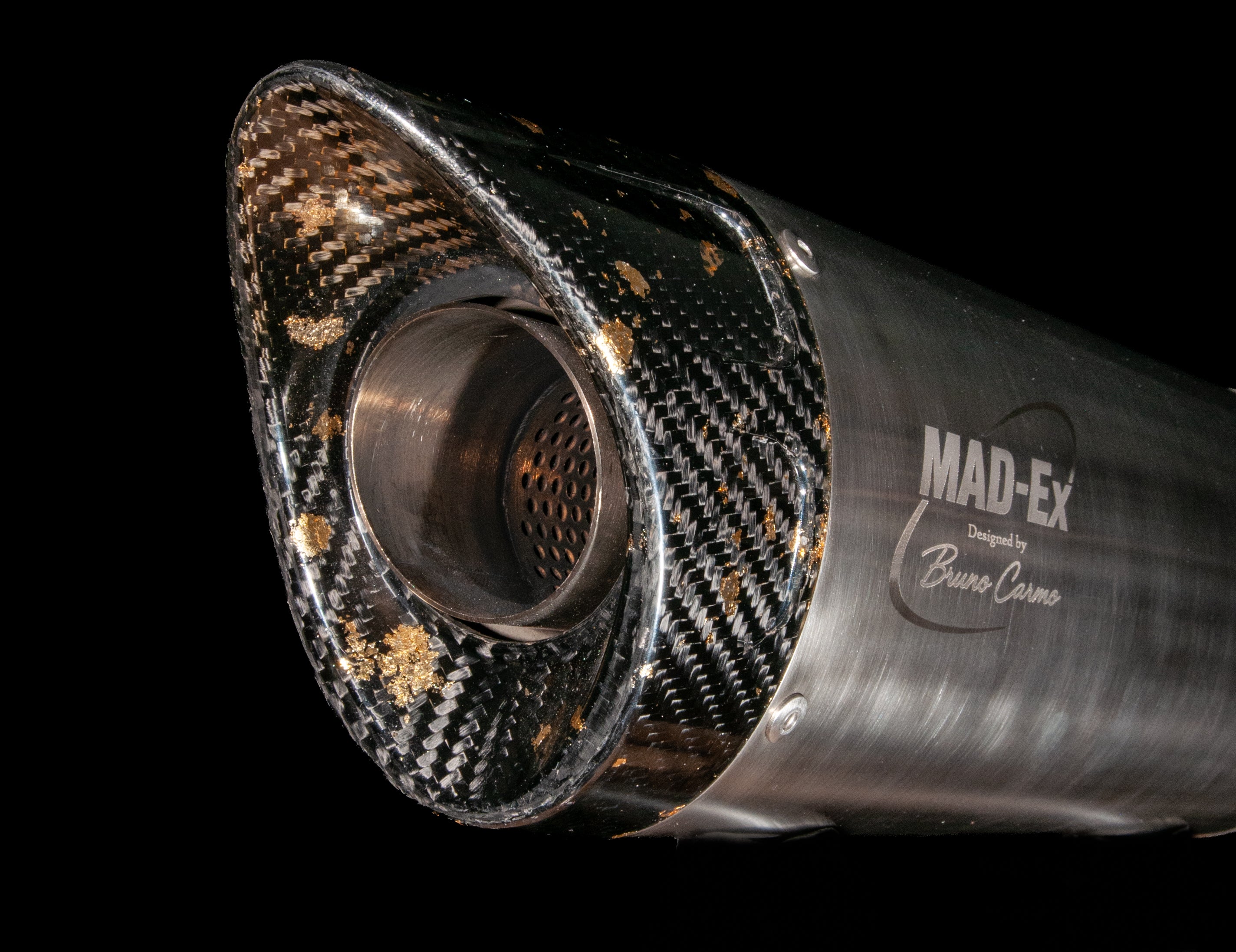 Carbon end cap and perforated inner core of the MAD-EX R1 race muffler, three-quarter studio photo on black
