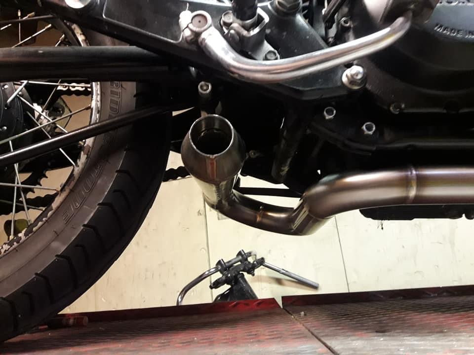 Close-up of the MAD Exhausts Cobra cone silencer outlet mounted under the Honda CB750 near the rear wheel