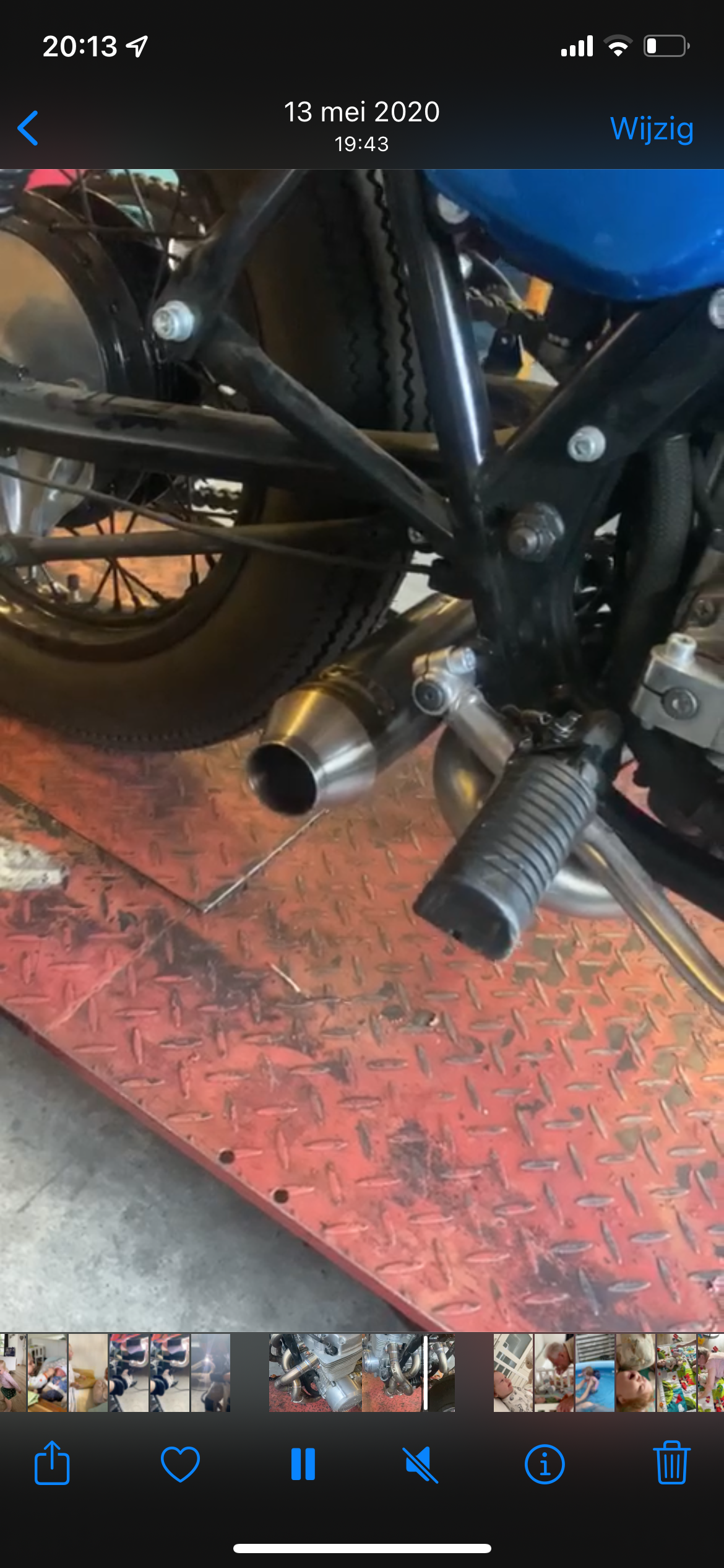Phone screenshot of the MAD Exhausts Cobra silencer outlet under a Honda CB750, rear view above the workshop floor